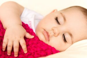 baby napping with red blanket