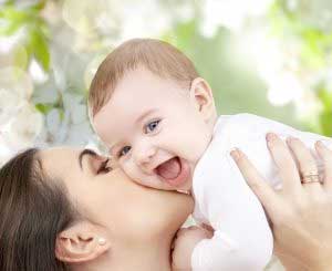 woman kissing baby's cheek outdoors