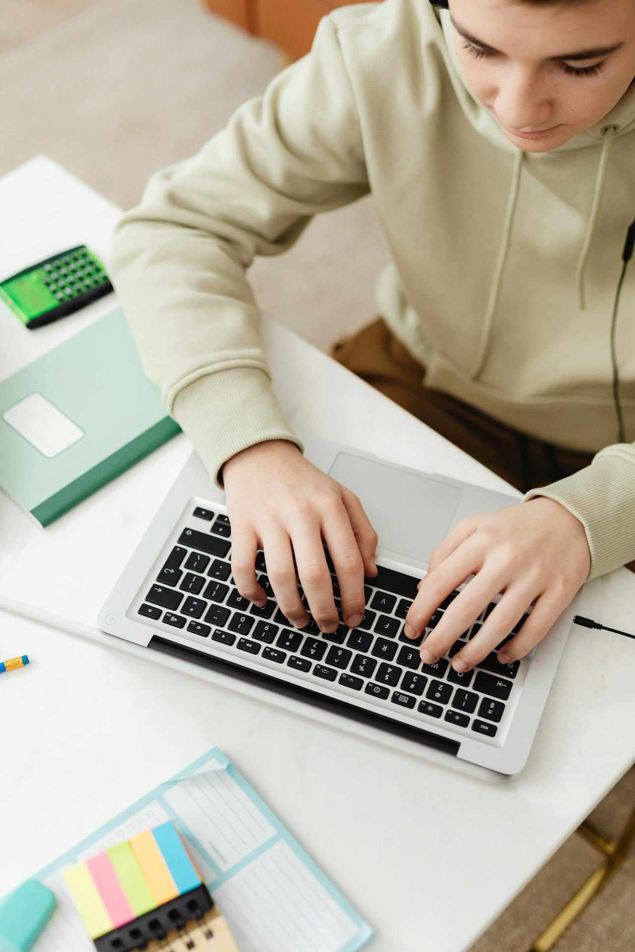 ADHD teen boy typing on his personal laptop doing his school work